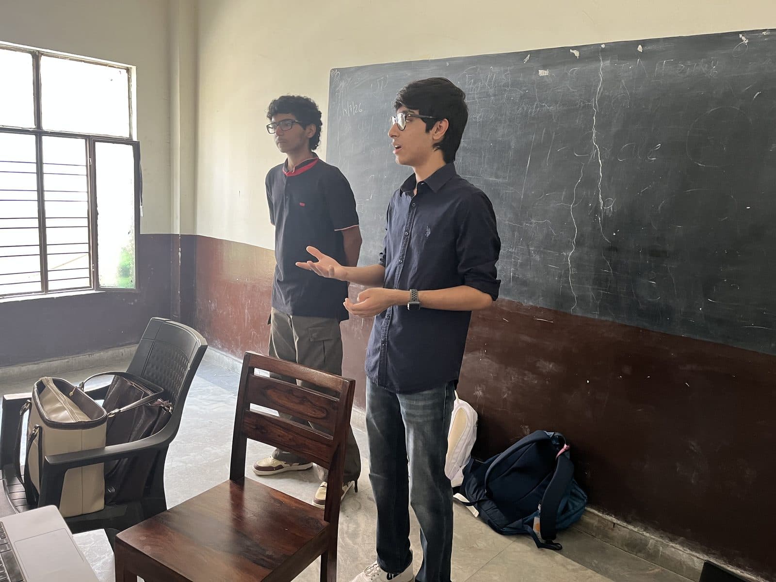 Two members of the Edugram team presenting at the blackboard at the front of a classroom at Dayal Public School.