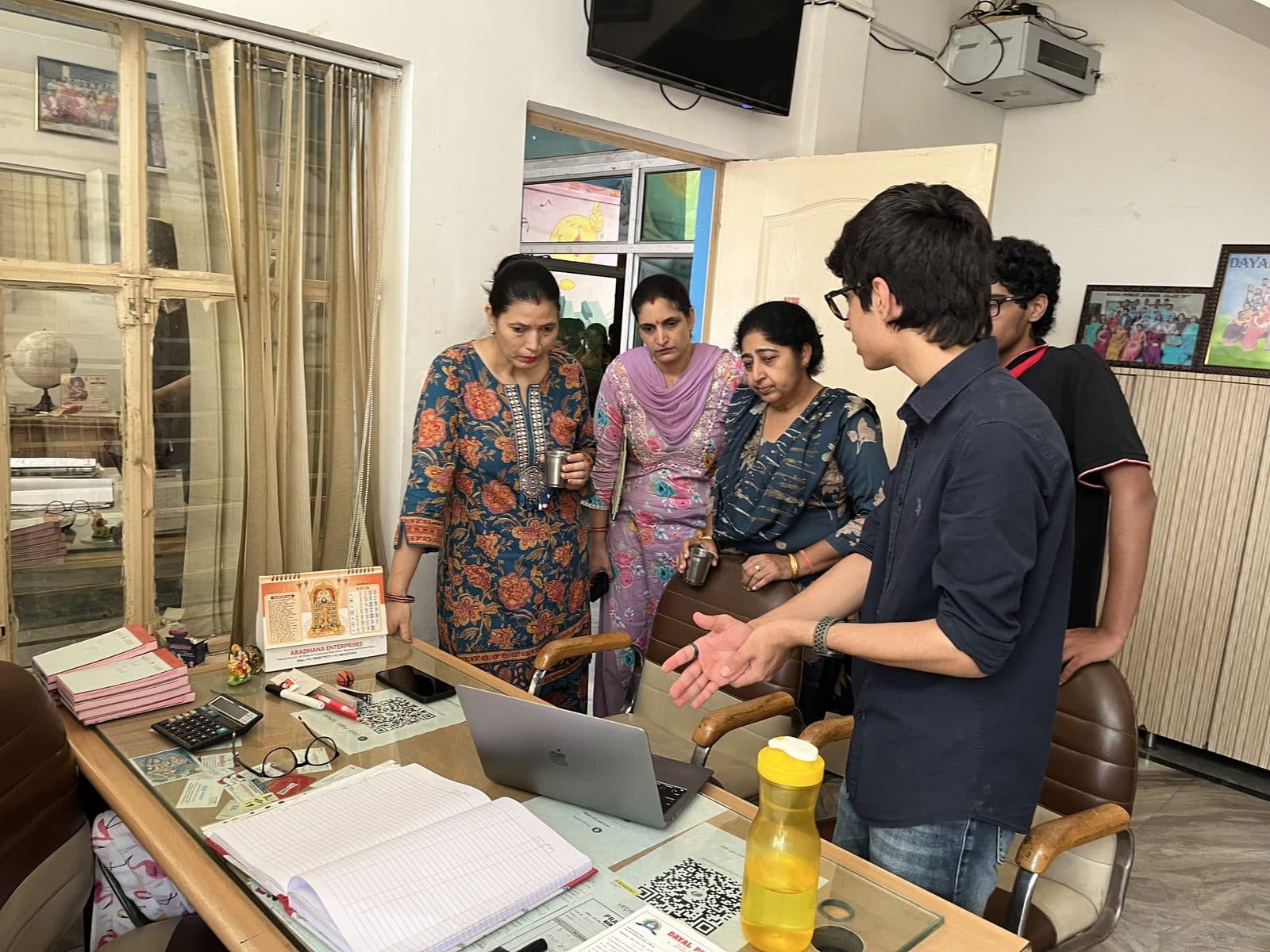 Members of the Edugram team showing the platform on a laptop to teachers in the Dayal Public School office.